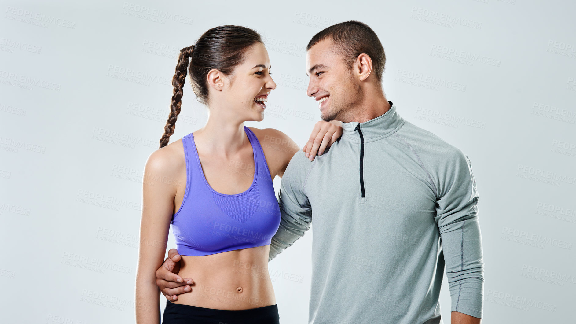 Buy stock photo Shot of a young couple standing in a studio wearing sports clothing
