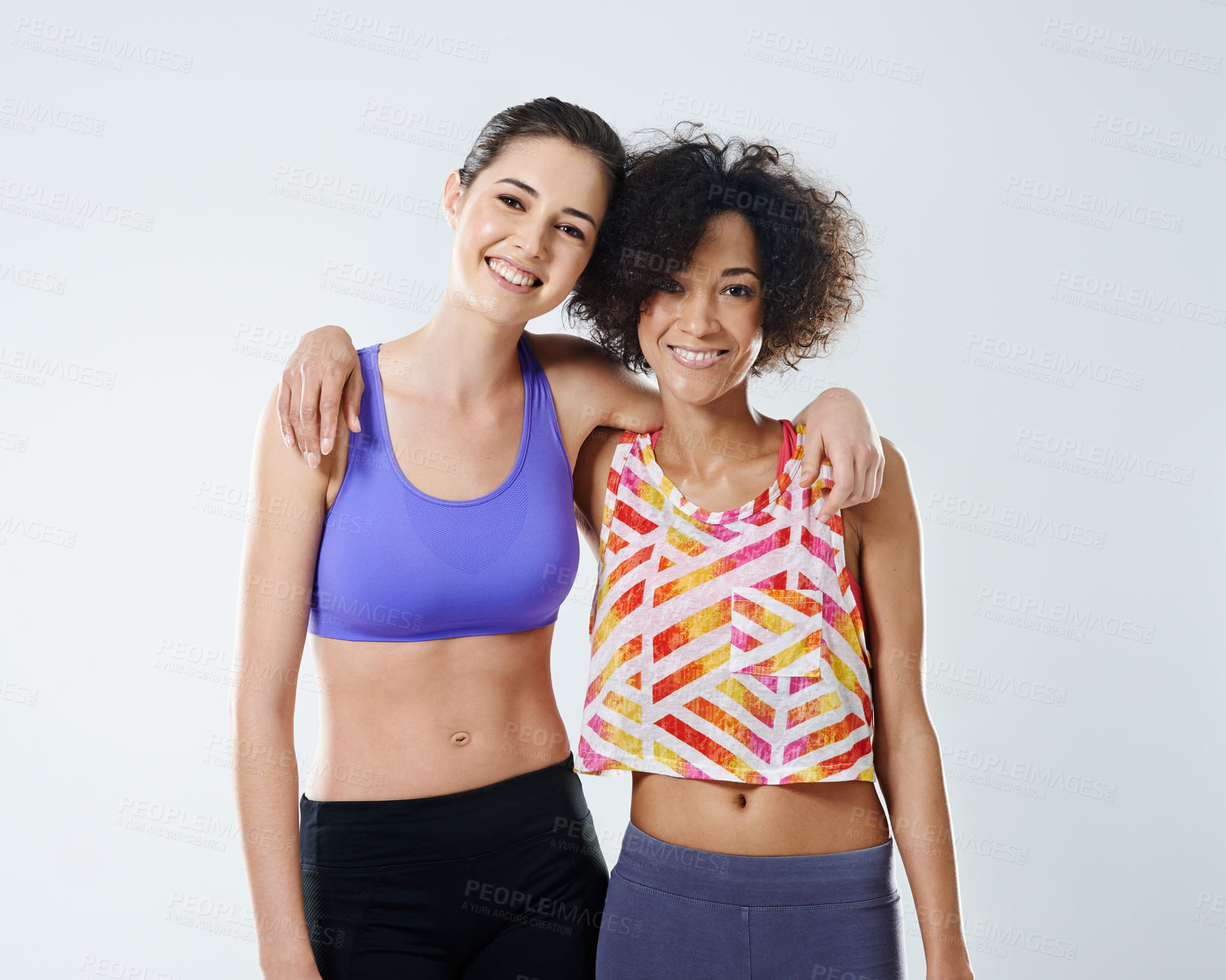 Buy stock photo Happy women, fitness and hug with support for exercise, training or workout together on a studio background. Young, female person or friends with smile, sportswear or care for health and wellness