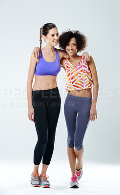 Buy stock photo Two beautiful young women in gymwear against a gray background