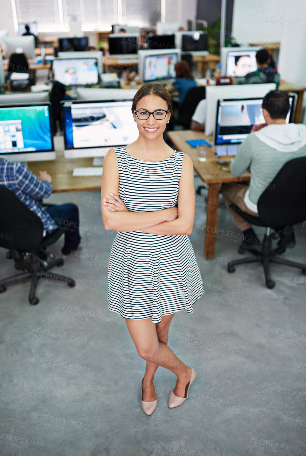 Buy stock photo Portrait of a young woman standing in an office with designers in the background