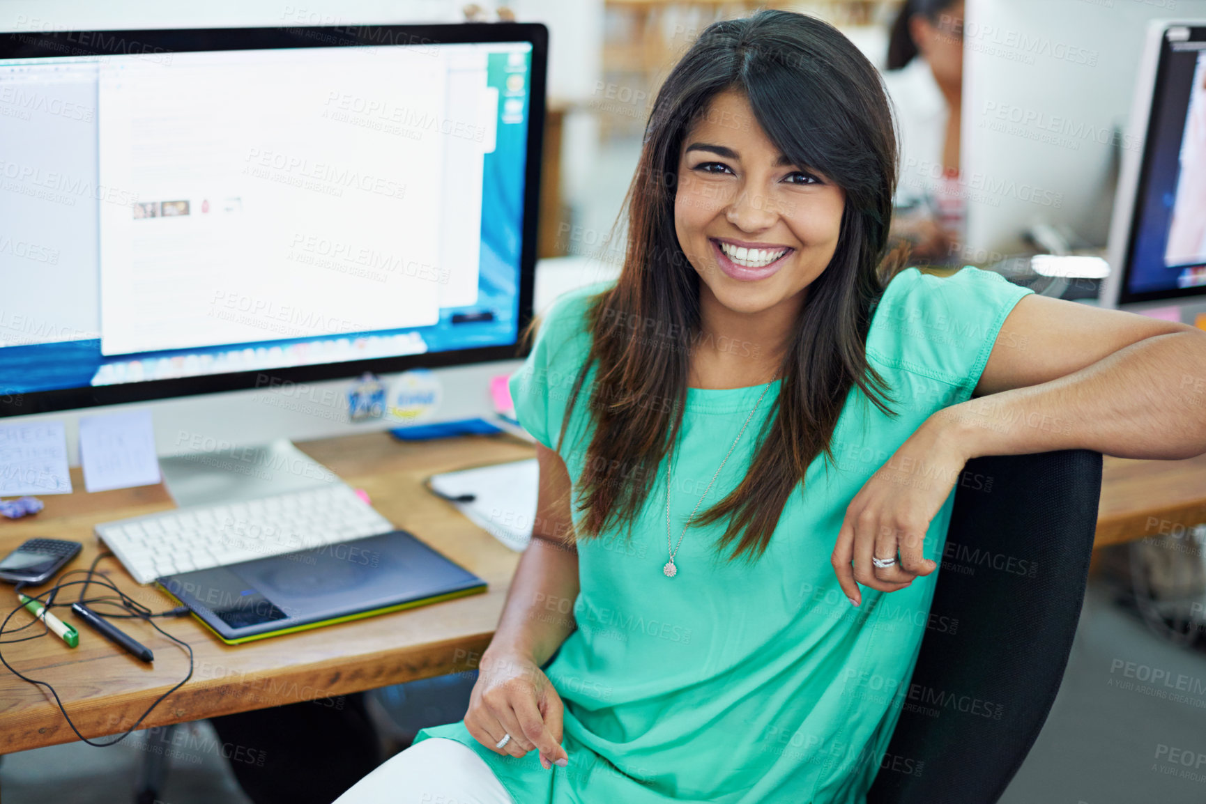 Buy stock photo Portrait of an attractive young woman sitting at her workstation in an office