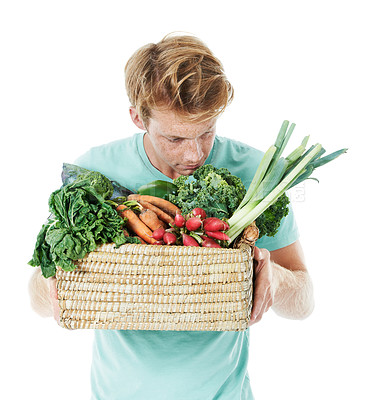 Buy stock photo Man, sniff vegetables and basket in studio, shopping and organic produce by white background. Person, thinking and container with groceries, nutrition or scent for vegan food with discount for diet