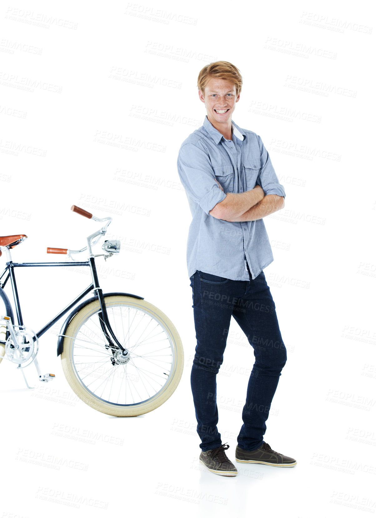 Buy stock photo A handsome young red-headed man standing next to an old-fashioned bicycle with his arms folded