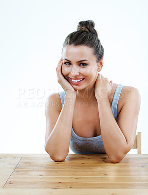 Buy stock photo Beautiful young woman sitting at a table and smiling at you