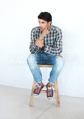 Buy stock photo Student, thinking and sitting in studio with fashion, casual style and confidence isolated on white background. Man, stool and contemplating, pride and chilling or relax with trendy outfit or clothes