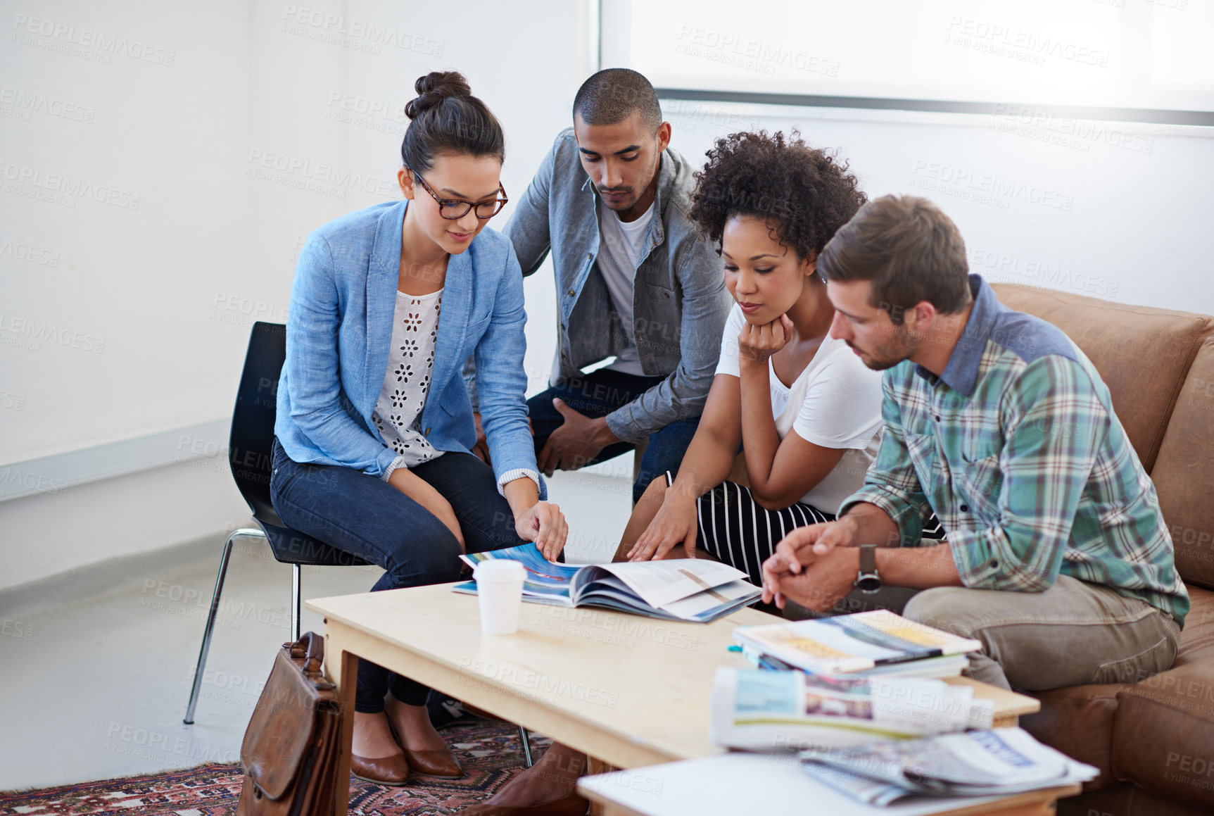 Buy stock photo Shot of a group of designers having a meeting around a coffee table