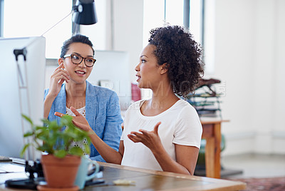 Buy stock photo Shot of two colleagues having a discussion at a computer in the office