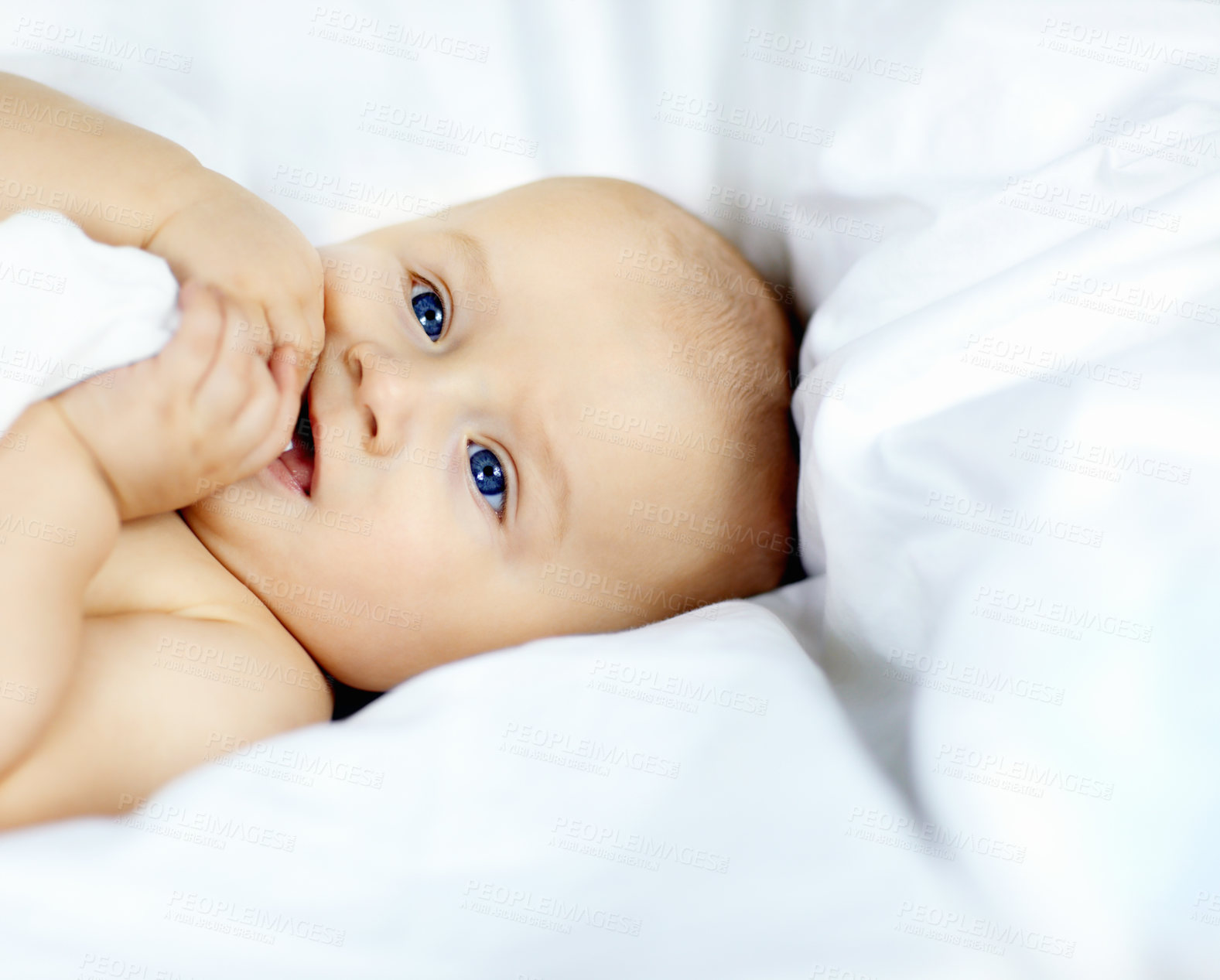 Buy stock photo Cute baby boy lying down and looking around with curiosity and wonder