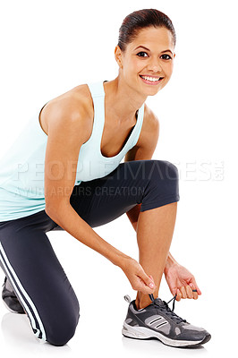 Buy stock photo Portrait of a beautiful young woman in gymwear tying her shoe 