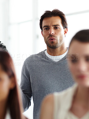 Buy stock photo A young businessman looking confused during a meeting