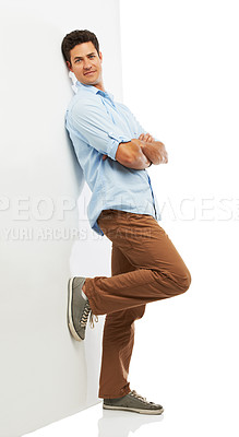 Buy stock photo A handsome young man leaning against a wall while isolated on a white background