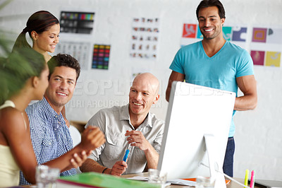 Buy stock photo A group of smiling designers working together at a computer