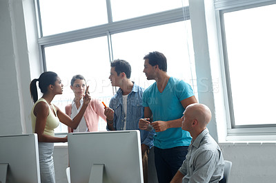Buy stock photo A group of colleagues standing in a office and engaging in an intense conversation
