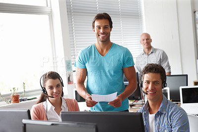 Buy stock photo Profile of a handsome supervisor standing with his colleagues in an office