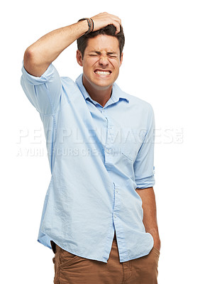 Buy stock photo A handsome young man holding his head in frustration against a white background