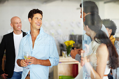 Buy stock photo A handsome young man with a glass of wine in his hand at an office social