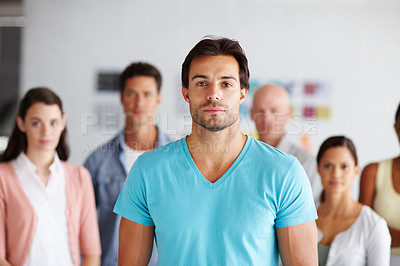 Buy stock photo A young man standing in front of his colleagues in their office