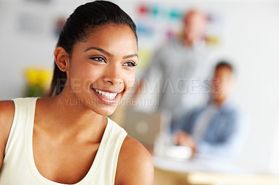 Buy stock photo Closeup shot of a young female designer smiling happily with coworkers in the background