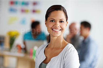 Buy stock photo Portrait of a positive-looking young professional with colleagues working in the background