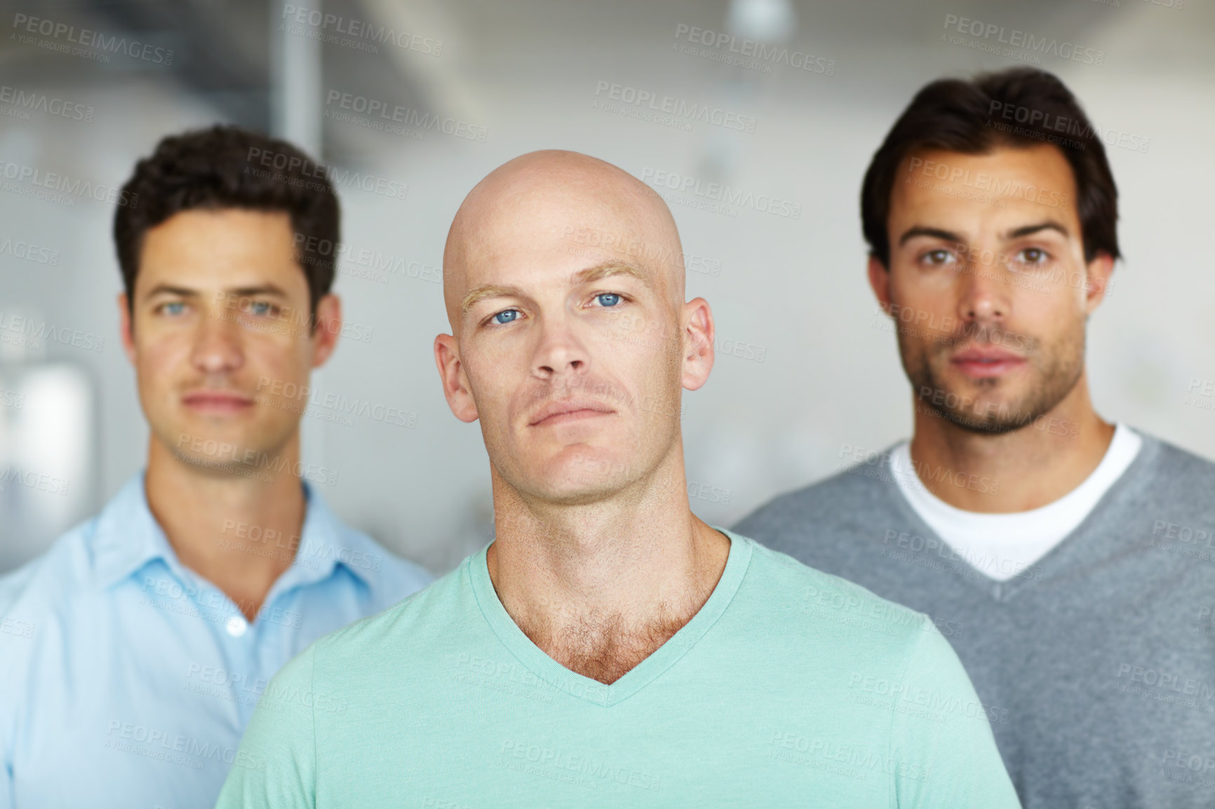 Buy stock photo Portrait of a three focused-looking young designers standing in an office