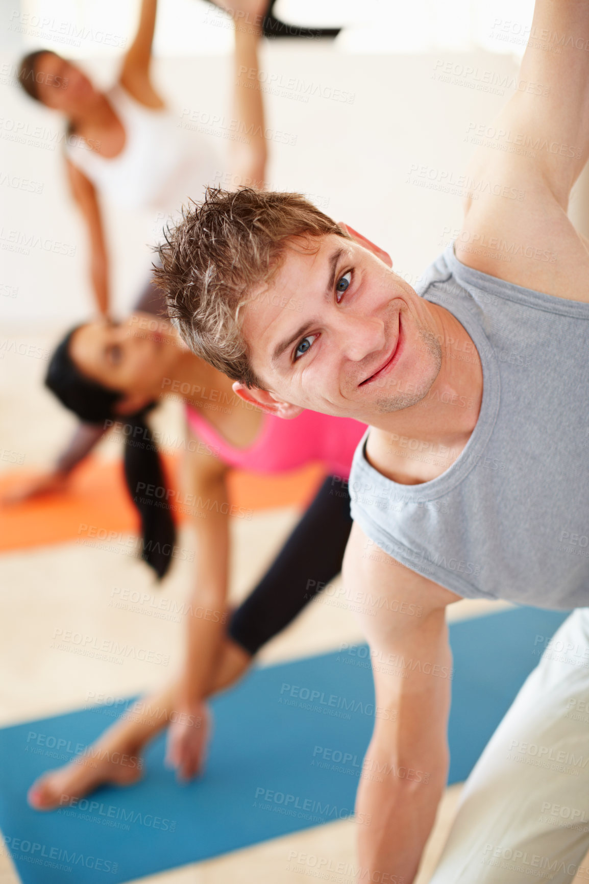 Buy stock photo Portrait, smile and stretching, happy man in yoga class for fitness, commitment and body wellness. Pilates, men and women in gym together for holistic health, mindfulness and person at exercise club.