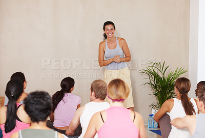 Buy stock photo A yoga instructor smiling happily at her class