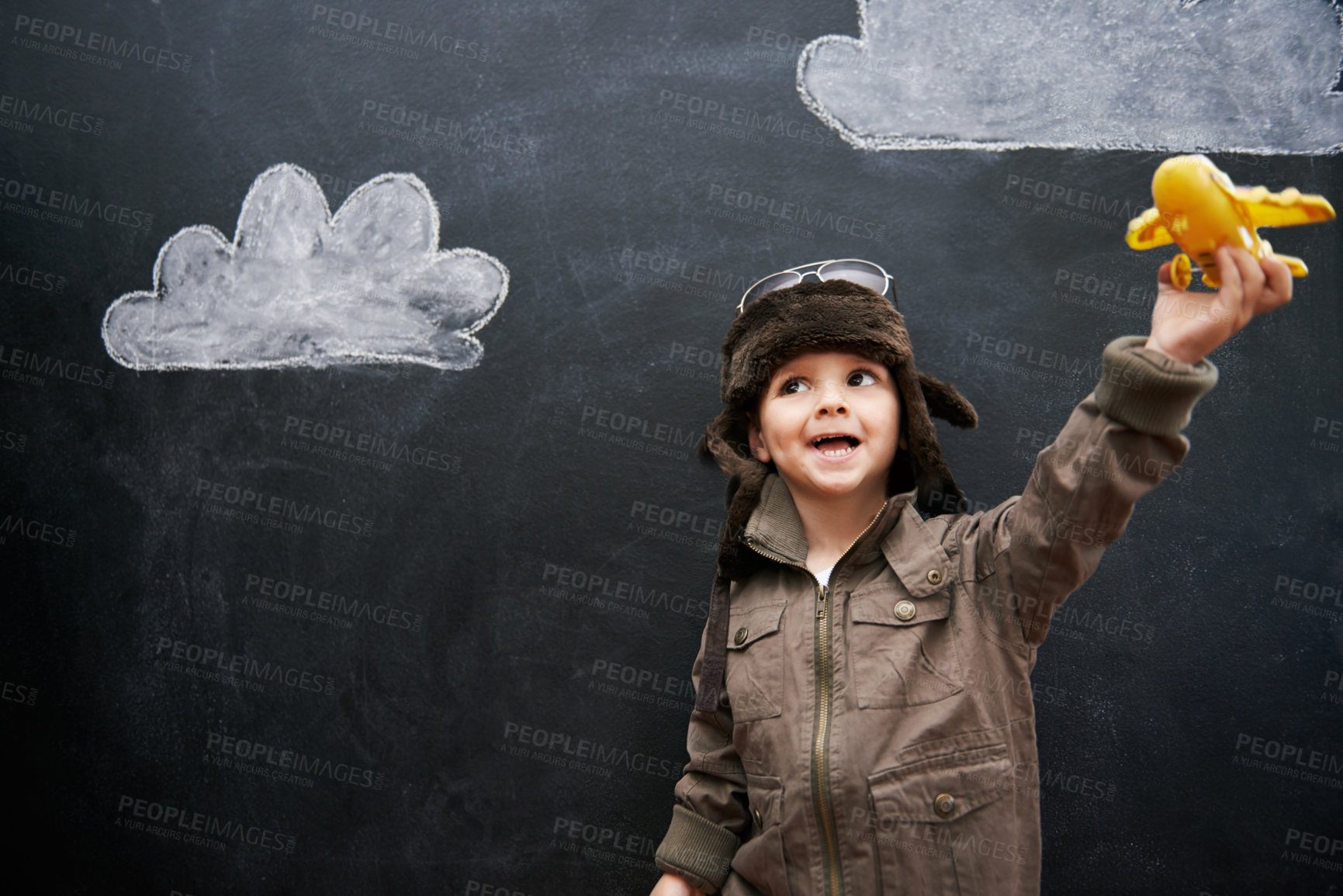 Buy stock photo Child, boy and happy by blackboard with plane for creative fun, playing and drawing of clouds for education. Student, kid and confidence with airplane, chalkboard or illustration for knowledge or sky