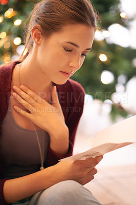 Buy stock photo Young woman reading christmas card, letter and emotional note in home living room during winter celebration, holidays and break. Female, festive message and xmas greeting card, wishes and kindness 