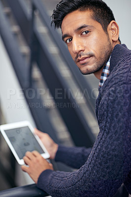 Buy stock photo A handsome businessman holding a digital tablet on a stairwell