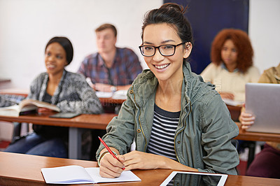 Buy stock photo Classroom, student and portrait with smile in university for answer, information and education. College, girl and students on campus for studying, writing and learning with books or tech for quiz
