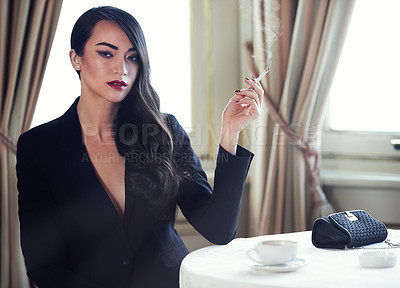 Buy stock photo Shot of a woman smoking a cigarette in a luxurious setting wearing classicly elegant attire