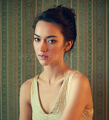 Buy stock photo Portrait of a beautiful young woman dressed elegantly in a wallpapered room