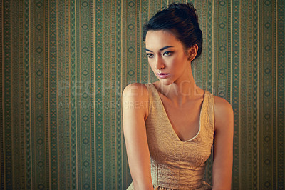 Buy stock photo Shot of a beautiful and elegant young woman posing in a green wallpapered room