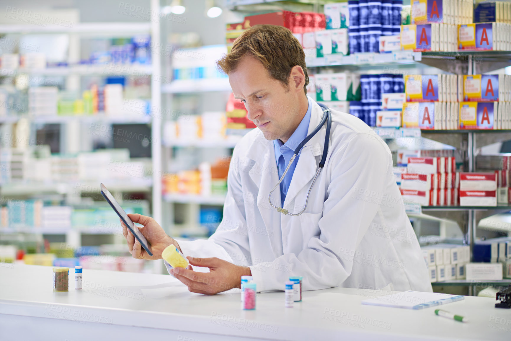 Buy stock photo Pharmacist, tablet and pills for prescription, checking or medicine in drugstore, chemist or services. Male person, doctor and pharmaceuticals in clinic for stock, inventory for information or advice