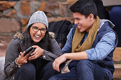 Buy stock photo Shot of a young couple laughing together on campus