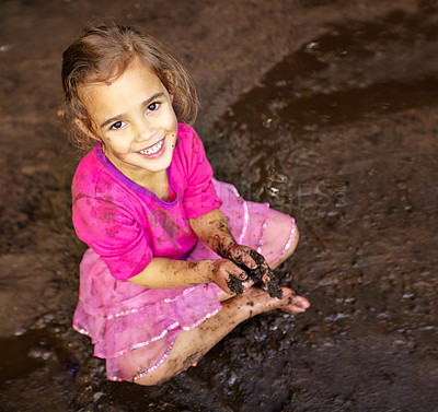 Buy stock photo Girl, child and portrait with happiness in mud for freedom, playing and muddy fun in sunshine weather or outdoor. Kid, female and face of person with smile for activity, enjoyment and relax in dirt