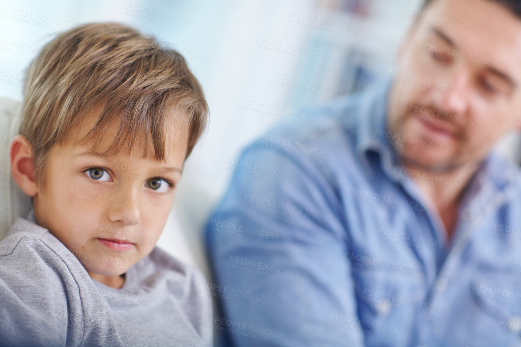 Buy stock photo Portrait of a father and son sitting on the sofa together at home