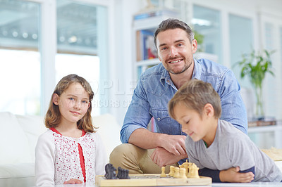 Buy stock photo Chess, learning or strategy with father and kids in living room together for bonding or planning. Board games, love or smile with dad, daughter and son playing in apartment for development or growth