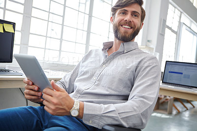 Buy stock photo Shot of a young designer using his digital tablet