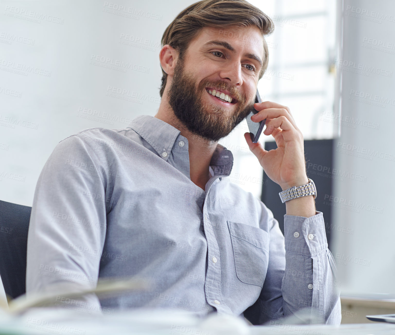 Buy stock photo Shot of a designer talking on his phone while reading something on his computer screen