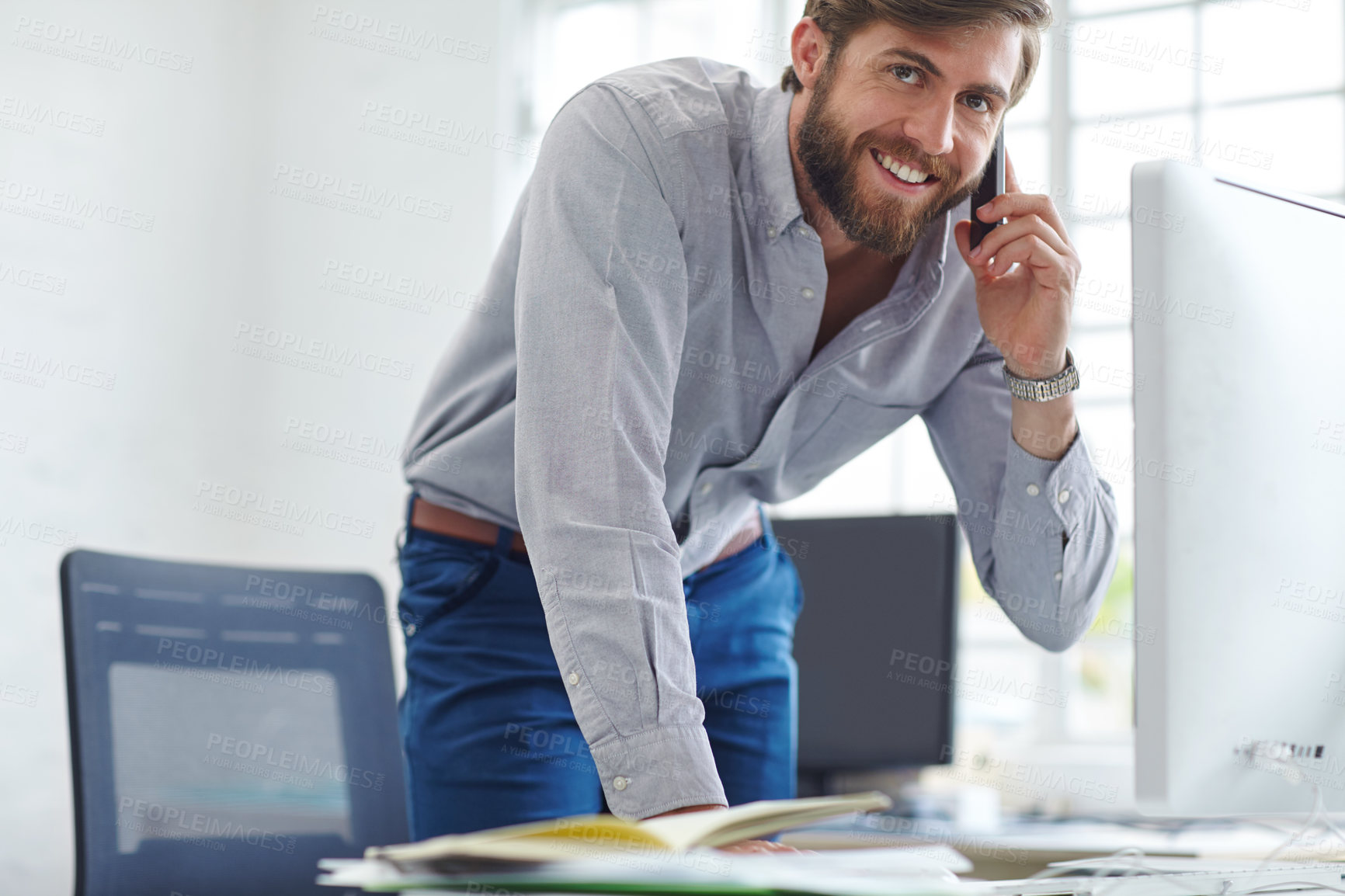 Buy stock photo Shot of a handsome designer talking on his phone at the office