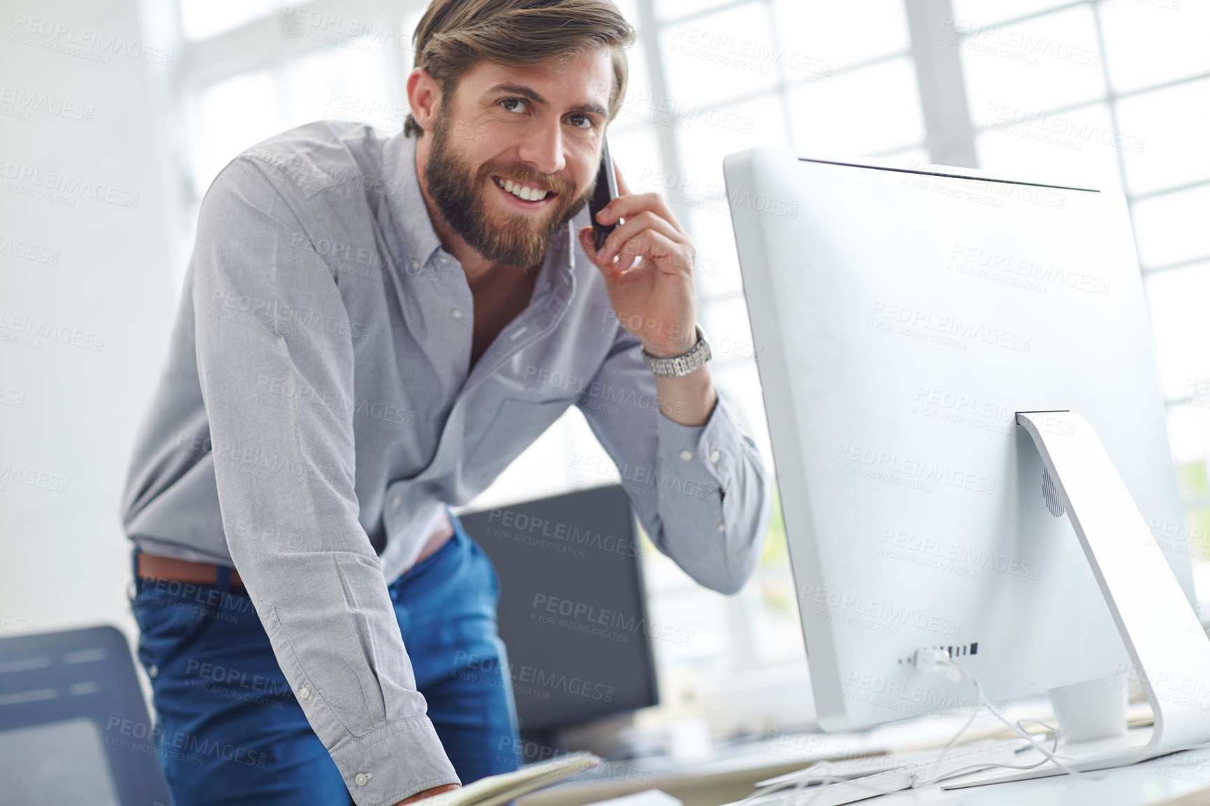 Buy stock photo Shot of a handsome designer talking on his phone at the office