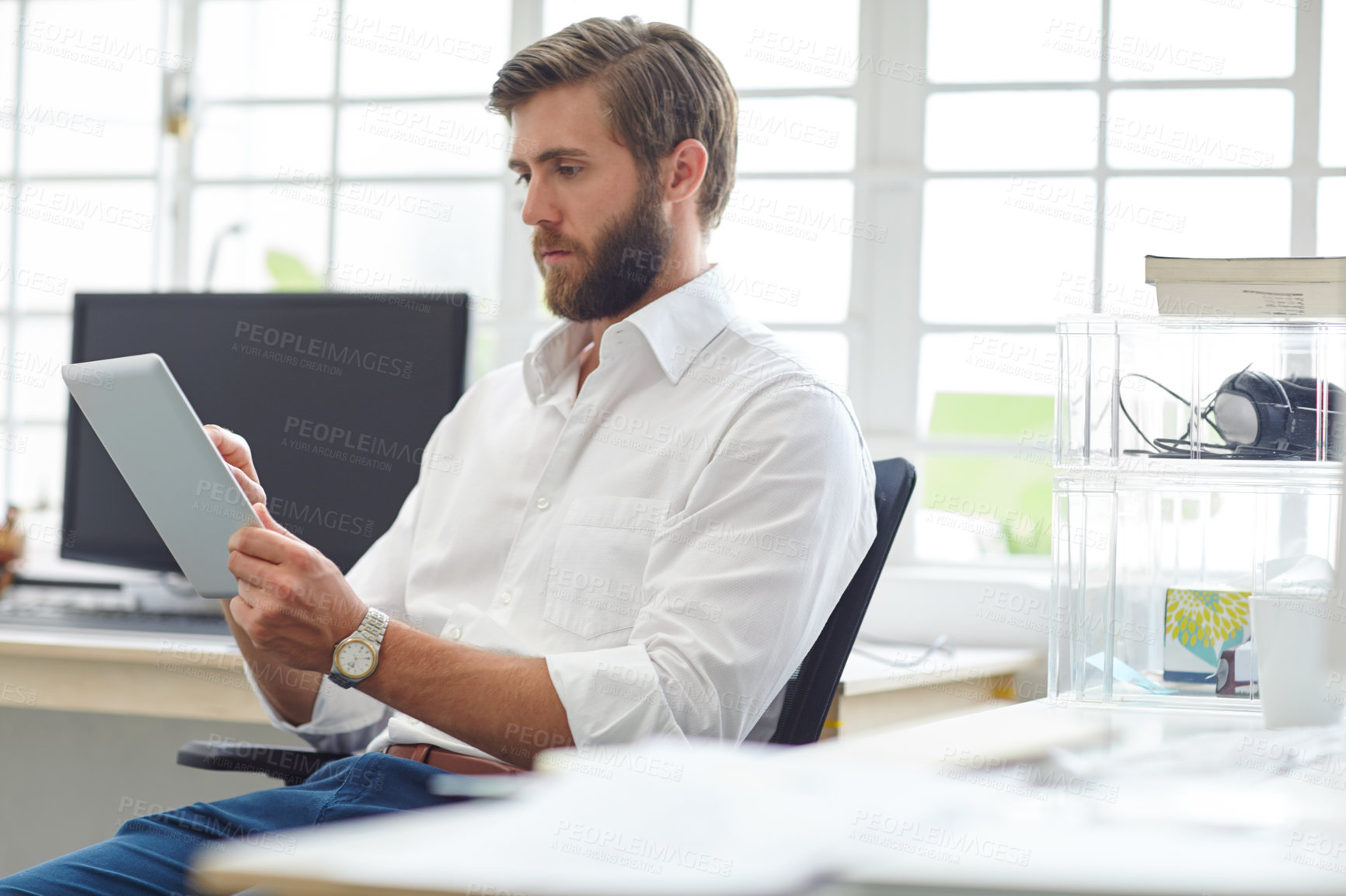 Buy stock photo Shot of a young designer using his digital tablet