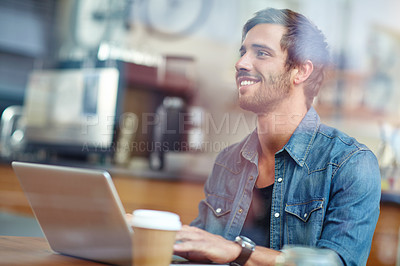 Buy stock photo Shot of a handsome young man sitting with his laptop in a coffee shop