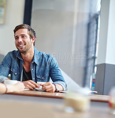 Buy stock photo Shot of a handsome young man on a coffee shop date with an unrecognizable woman