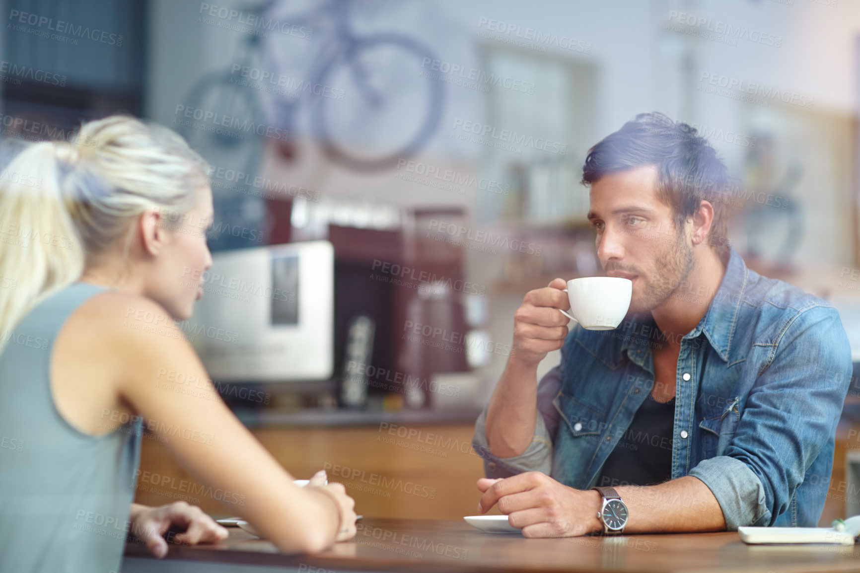 Buy stock photo Shot of a young couple enjoying a date at a coffee shop