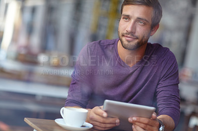 Buy stock photo Shot of a handsome young man looking thoughtful while sitting with his tablet in a coffee shop