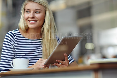 Buy stock photo Shot of a beautiful young woman sitting with her tablet in a coffee shop
