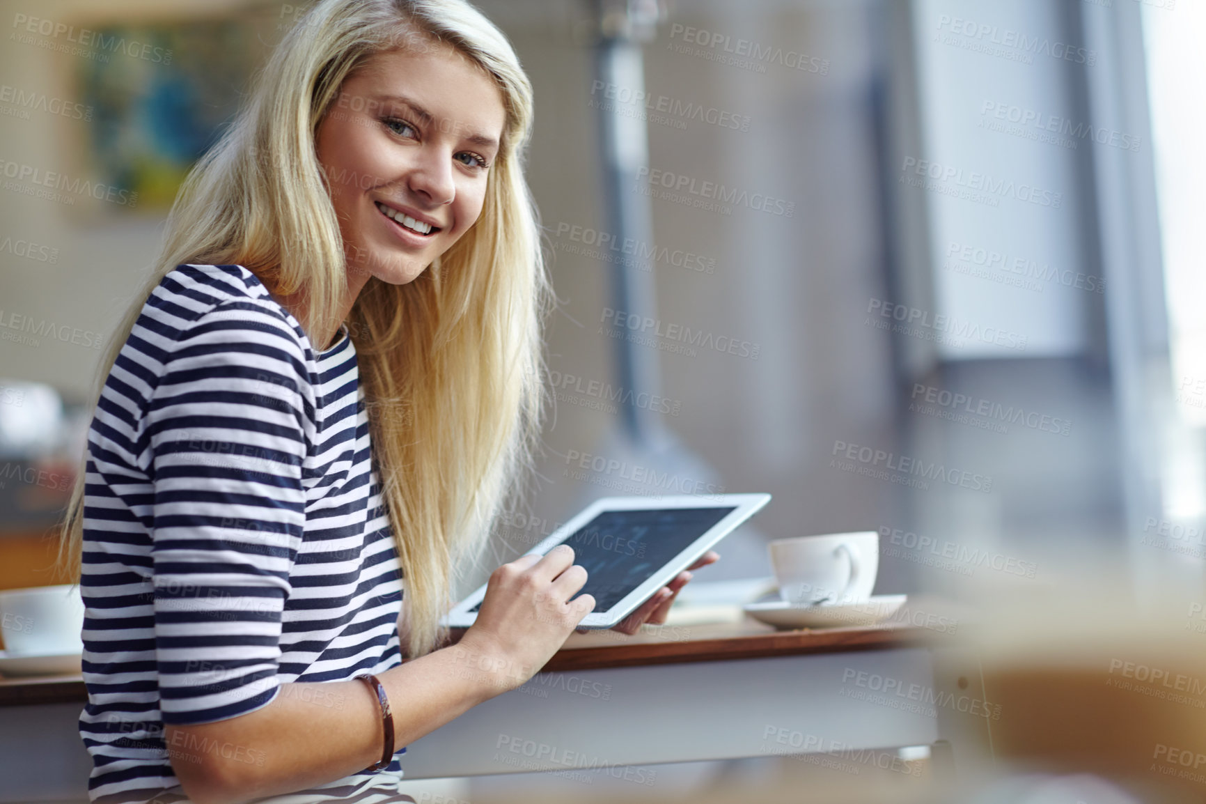 Buy stock photo Portrait of a beautiful young woman sitting with her tablet in a coffee shop