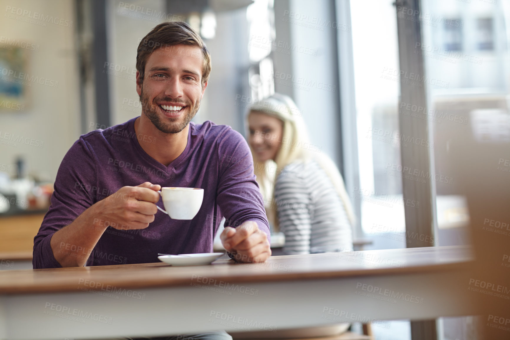 Buy stock photo Portrait of a handsome young man drinking a cup of coffee at a cafe